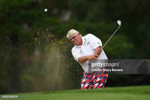 John Daly hits from a green side bunker on the first hole during the first round of the Ally Challenge presented by McLaren at Warwick Hills Golf &...