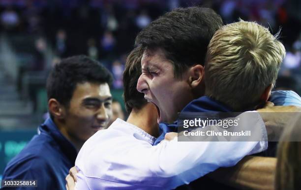 Jurabek Karimov of Uzbekistan celebrates with his team mates after his five set victory against Cameron Norrie of Great Britain during day one of the...