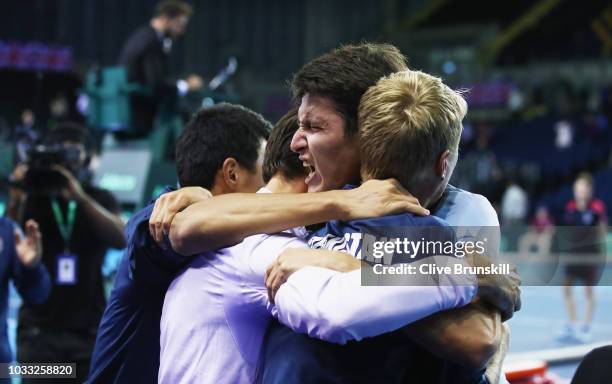 Jurabek Karimov of Uzbekistan celebrates with his team mates after his five set victory against Cameron Norrie of Great Britain during day one of the...