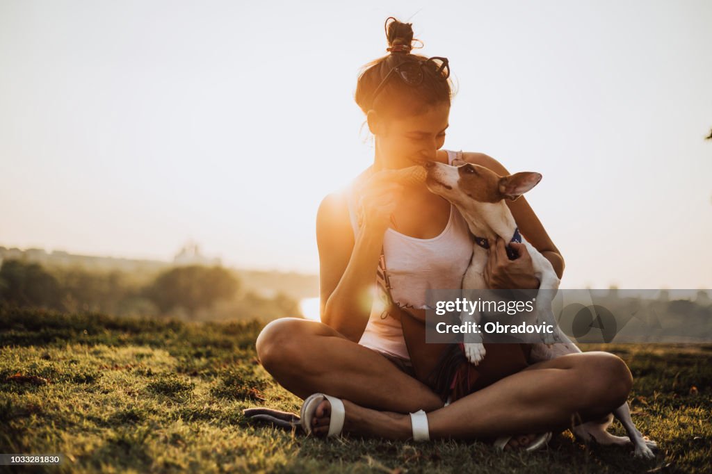 Young woman with dog eating ice cream