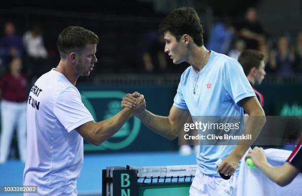 Jurabek Karimov of Uzbekistan shakes hands with Great Britain team captain Leon Smith after his five set victory against Cameron Norrie of Great...