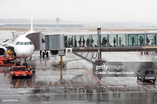 passengers boarding an airplane through a boarding bridge - passenger boarding bridge stock pictures, royalty-free photos & images