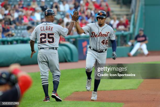 Detroit Tigers third baseman Jeimer Candelario gets a high five from Detroit Tigers third base coach Dave Clark after leading off the game with a...