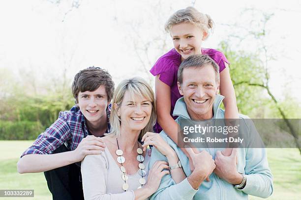 lächeln familie umarmen im freien - mother with daughters 12 16 stock-fotos und bilder