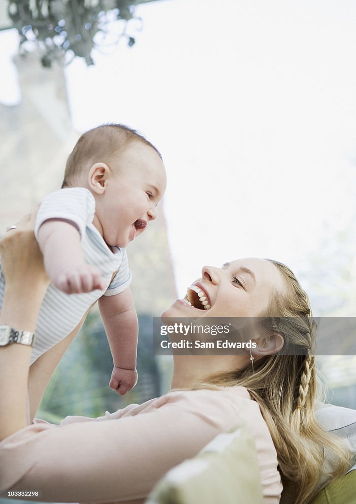 Smiling mother holding baby son