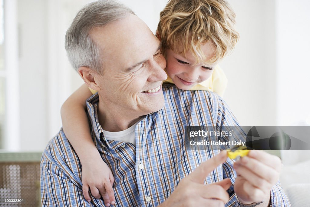 Abuelo y nieto jugando con coche de juguete