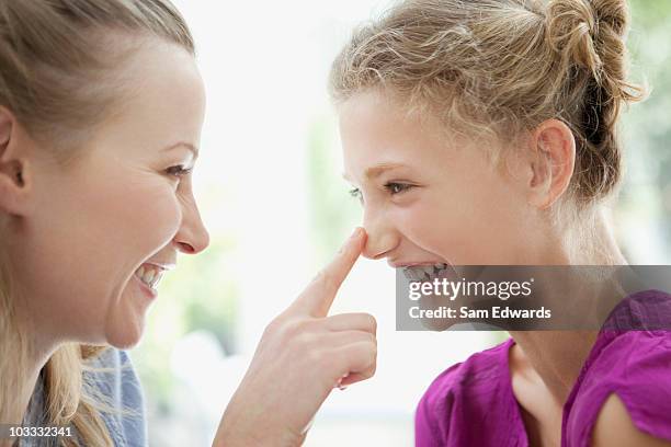 smiling mother touching daughters nose - human nose stock pictures, royalty-free photos & images