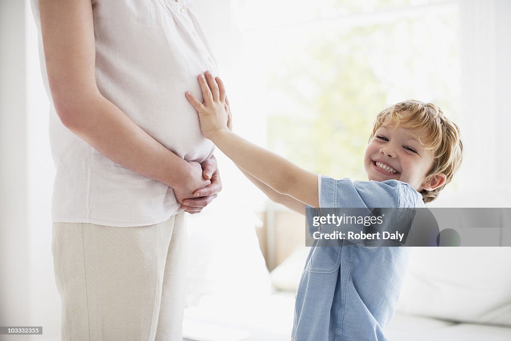 Madre figlio sorridente toccare incinta stomaco