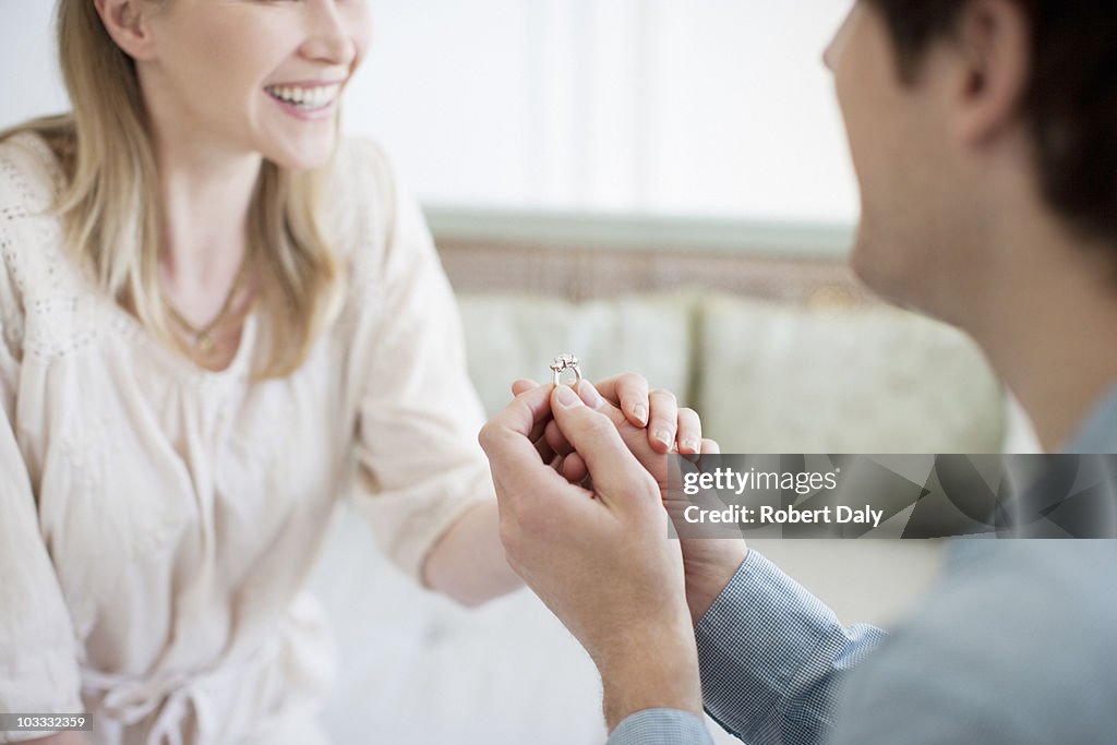 Man with engagement ring proposing marriage to woman