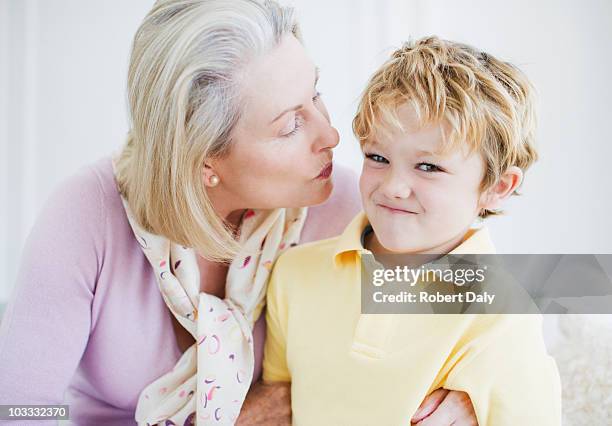 grandson refusing grandmothers kiss - old women kissing stock pictures, royalty-free photos & images