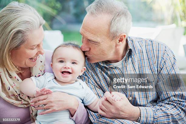 grandparents holding baby grandson - sam day stockfoto's en -beelden