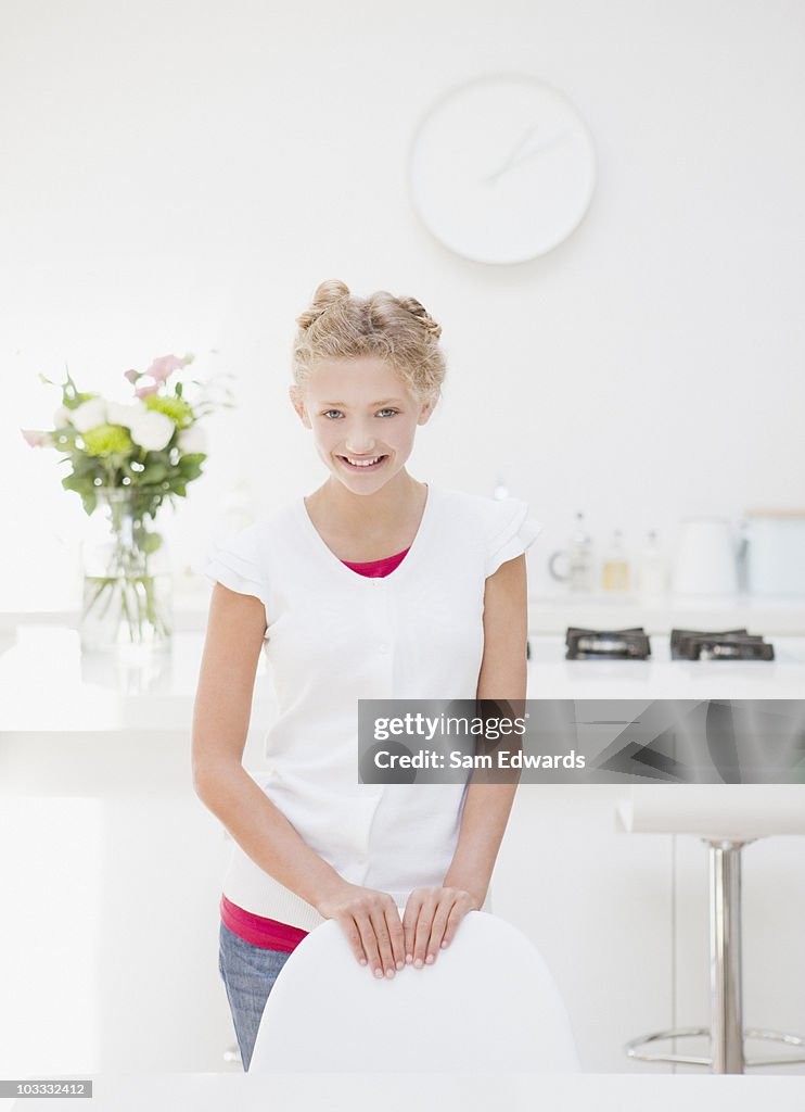 Menina sorridente na mesa na cozinha