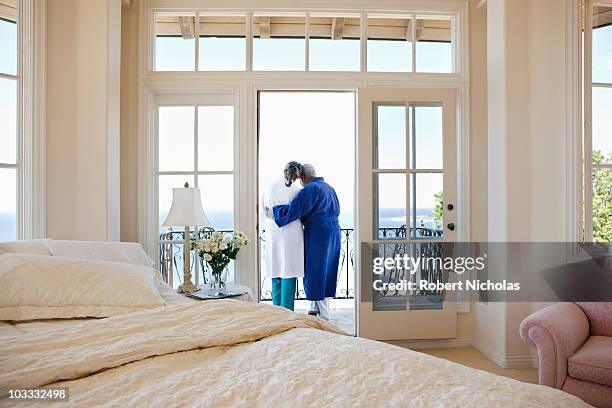 senior couple hugging on balcony - hotel balcony stock-fotos und bilder