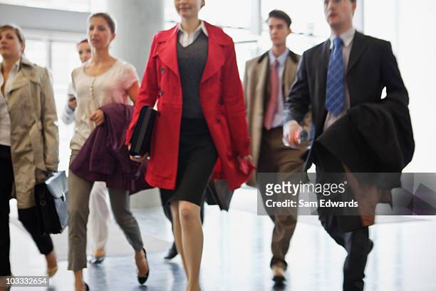 las personas de negocios, caminando en el lobby - devolver fotografías e imágenes de stock
