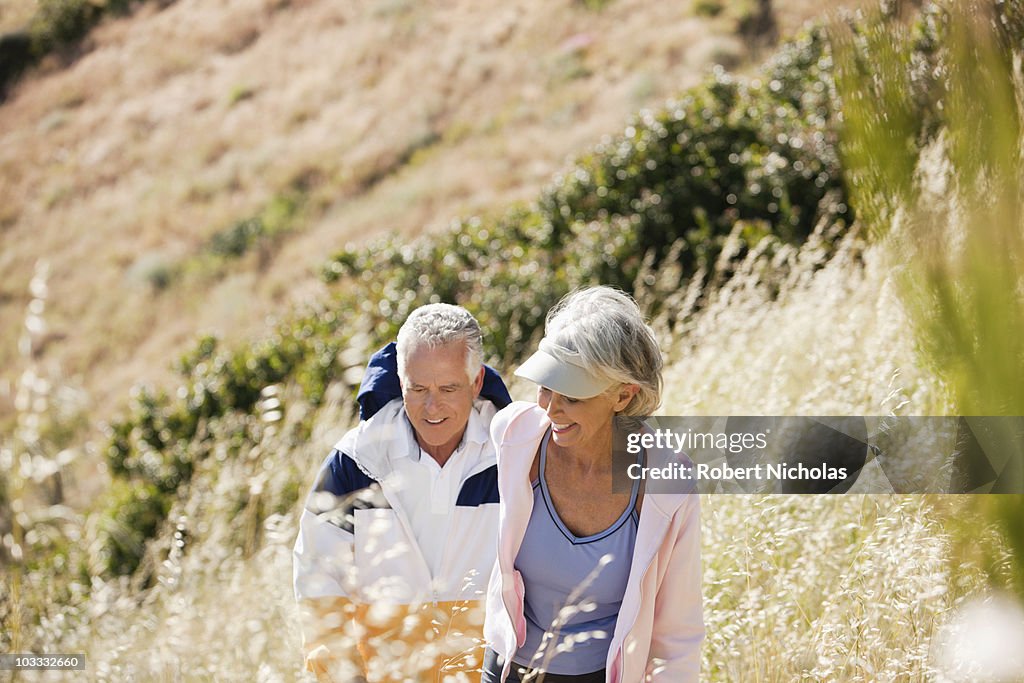 Senior couple hiking up hill