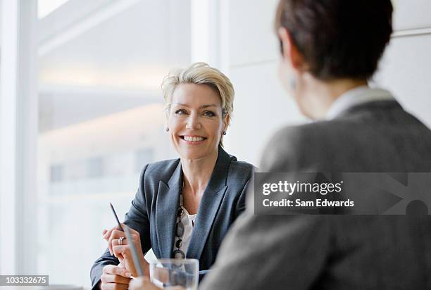 lächelnd geschäftsfrauen in den meetingräumen - two people talking face to face stock-fotos und bilder