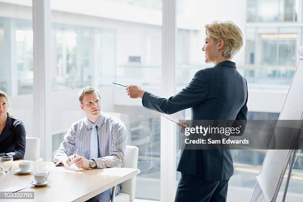 businesswoman leading discussion in meeting - business woman pointing stock pictures, royalty-free photos & images