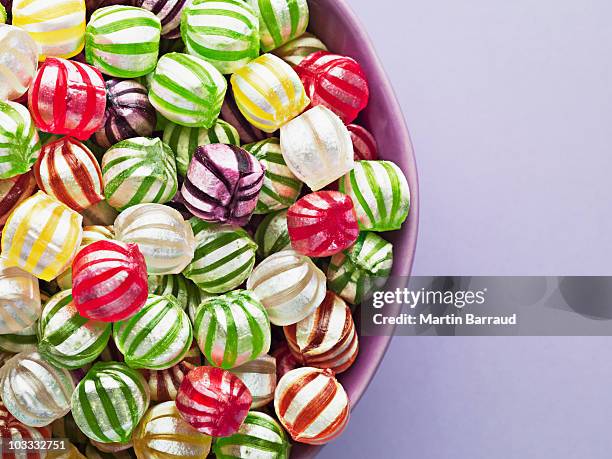 close up of vibrant hard candy in bowl - harde-snoep stockfoto's en -beelden