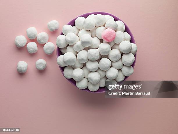bowl of white bon bons and one pink mint - fish out of water bowl stock pictures, royalty-free photos & images
