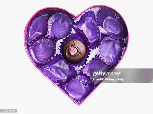 close up of chocolate and empty wrappers in heart-shape box - box of chocolates stock pictures, royalty-free photos & images