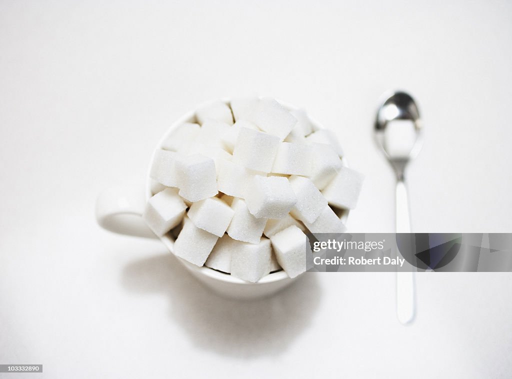 Coffee cup filled with sugar cubes