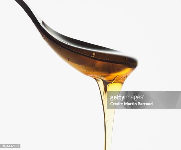 close up of honey dripping from spoon - molasses bildbanksfoton och bilder