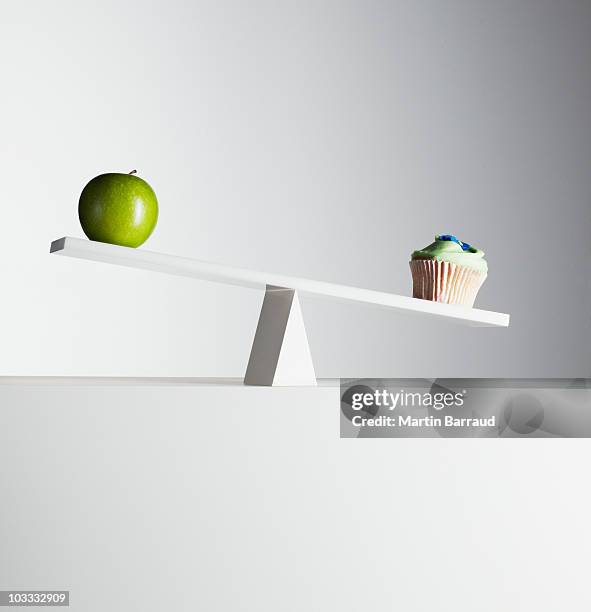 cupcake verzierungen wippe mit grünen apfel am anderen ende - weight scale stock-fotos und bilder