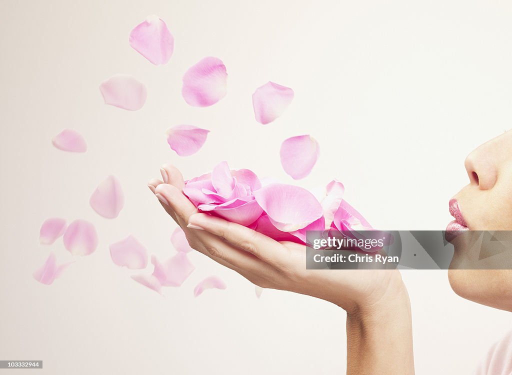 Mulher caindo pétalas de rosas cor-de-rosa