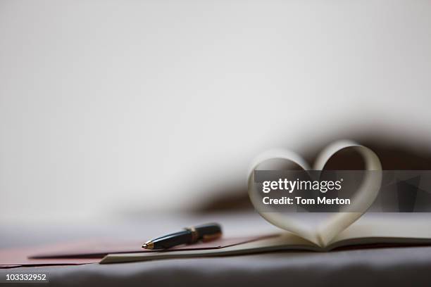 pen and pages of notebook forming heart-shape - pen stock pictures, royalty-free photos & images