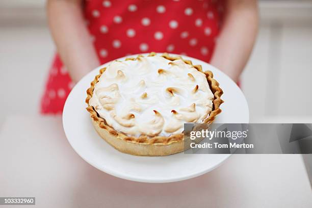 woman holding lemon meringue pie - britain 2010 to present day stock pictures, royalty-free photos & images