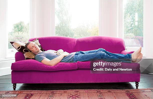 man napping on sofa - napping fotografías e imágenes de stock