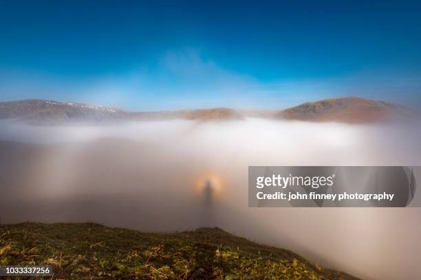 natural phenomena, brocken spectre on helm crag. lake district national park. uk. - brockengespenst stock-fotos und bilder
