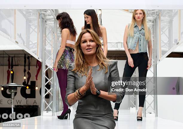 Australia television personality Charlotte Dawson poses in front of models showcasing designs by Voodoo Hosiery on the catwalk at a media preview of...