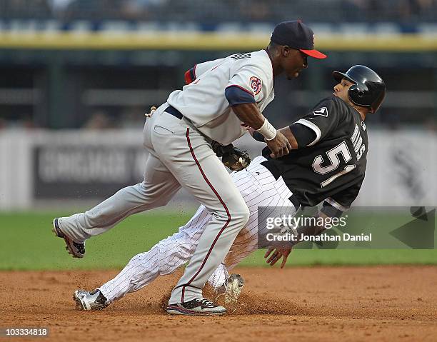 Orlando Hudson of the Minnesota Twins hops out of the way after tagging out Alex Rios of the Chicago White Sox at 2nd base at U.S. Cellular Field on...