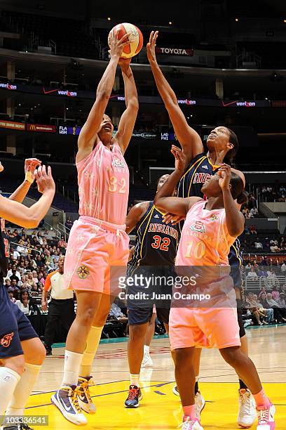 Tina Thompson of the Los Angeles Sparks goes to the basket against Tammy Sutton-Brown of the Indiana Fever as Sparks teammate Andrea Riley looks on...
