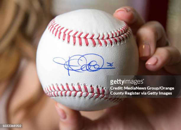 Kristen Weaver displays a baseball signed by her husband Jered Weaver of the Angels. The signed baseballs will be part a charity fundraiser on...