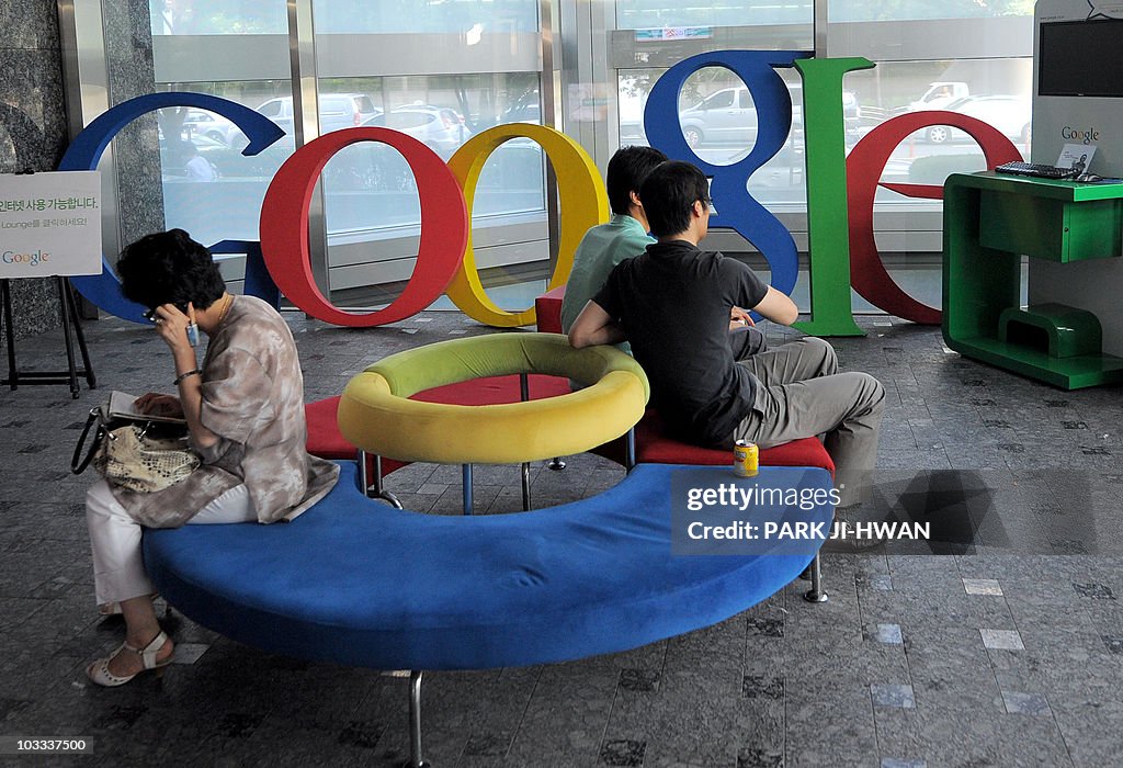 Visitors sit on a bench at a lobby of an