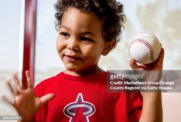 Tyson Kendrick son of Angel Howie Kendrick, holds a baseball signed by his dad. The signed baseballs will be part of a fundraiser on Saturday, June...