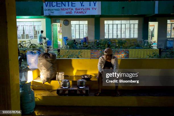 Man cooks a meal at a temporary evacuation center at Balzain East Elementary School ahead of Typhoon Mangkhut's arrival in Tuguegarao, Cagayan...