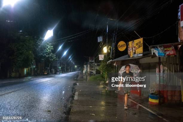 Man with an umbrella walks during heavy rainfall ahead of Typhoon Mangkhut's arrival in Tuguegarao, Cagayan province, the Philippines, on Friday,...