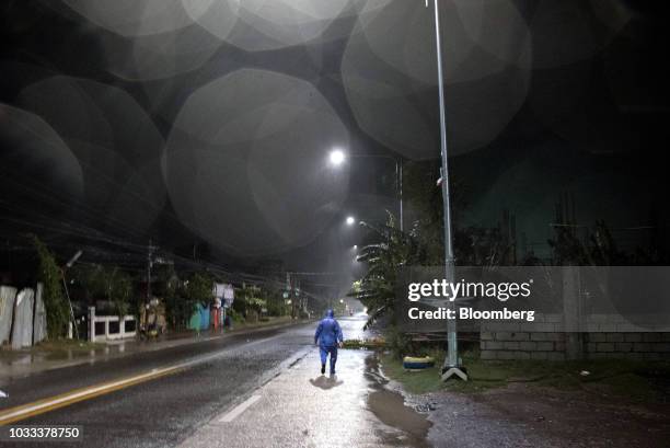 Man dressed in a raincoat walks on an empty street ahead of Typhoon Mangkhut's arrival in Tuguegarao, Cagayan province, the Philippines, on Friday,...
