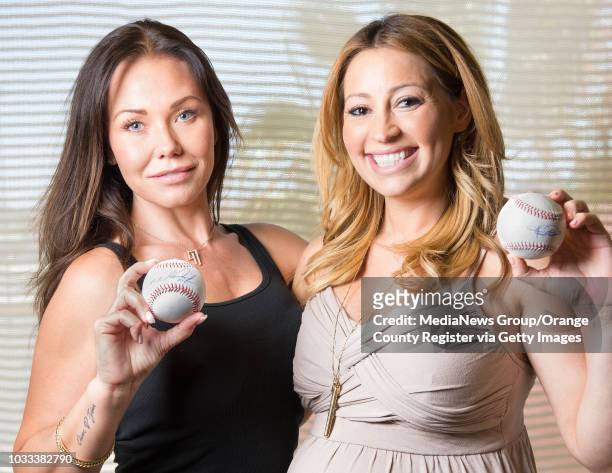 Angel wives, Jody Kendrick, left, and Kristen Weaver, holding baseballs signed by their husbands, Howie Kendrick and Jered Weaver, are holding a...