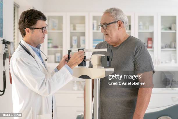 senior man getting a medical examination - doctor's office scale stock pictures, royalty-free photos & images