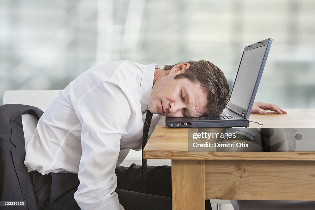 Businessman sleeping on laptop