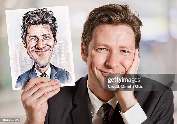 businessman holding caricature of himself - caricatura - fotografias e filmes do acervo