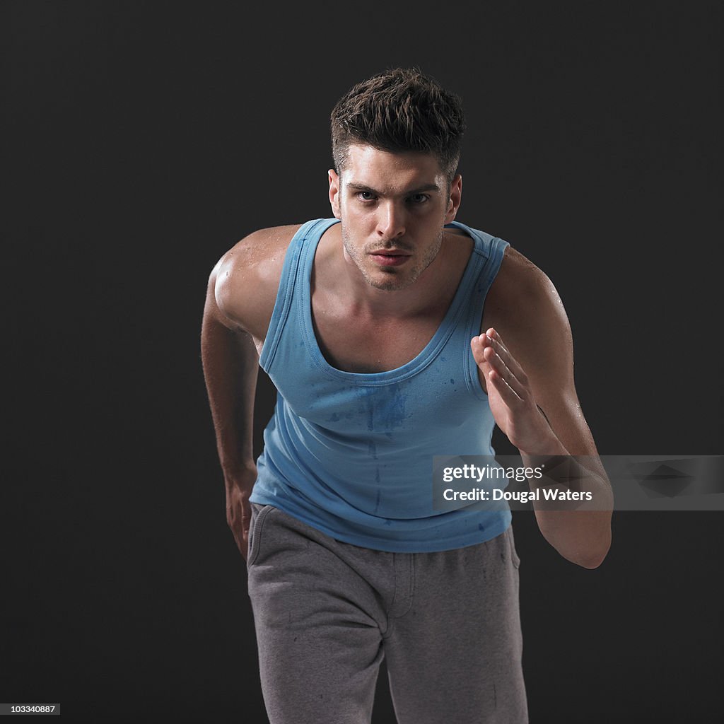 Male runner against black background.