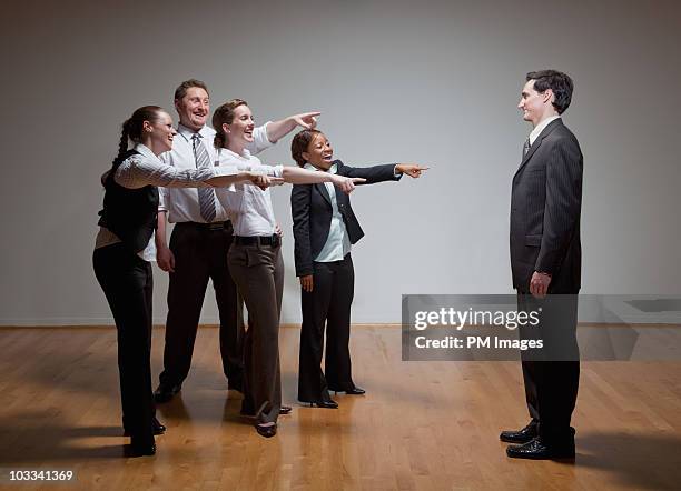 business people laughing at man - embarrassment foto e immagini stock