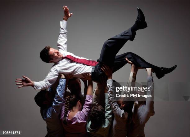 colleagues lifting up businessman - colleague appreciation stock pictures, royalty-free photos & images