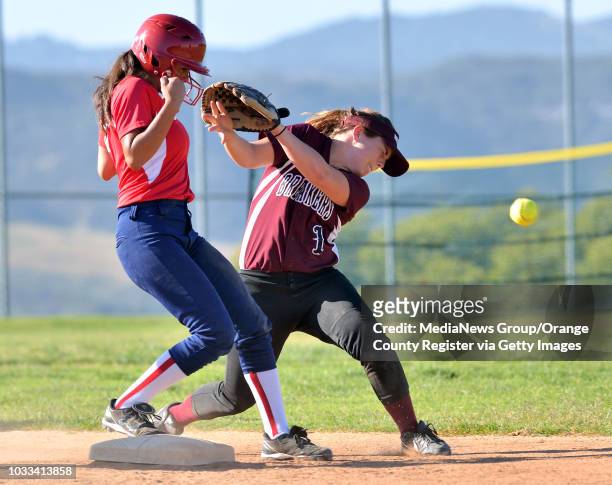 Kayleen Rodrigquez, left, of Bolsa Grande gets back to second base safely after the throw for an attempted pick-off gets past Jessica Roediger,...