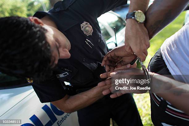 City of Miami police officer, Eldys Diaz, unlocks a pair of handcuffs on a person after transporting them to be processed while patrolling the...